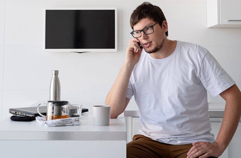 young man with a white t shirt using his fongo home phone device